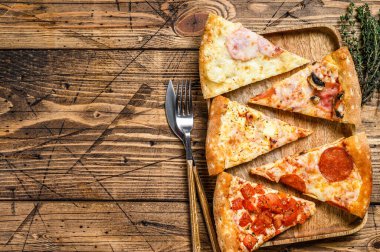 Farklı pizza çeşitleri var. Ahşap arka plan. Üst Manzara. Boşluğu kopyala