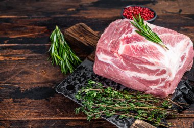 Kasap satırıyla ahşap kesme tahtasındaki taze biftekler için domuz eti. Koyu ahşap arka plan. Üst Manzara. Boşluğu kopyala