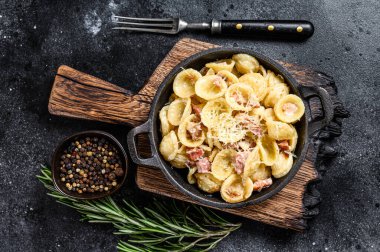 Pancetta, yumurta, sert parmesan peyniri ve krem soslu ev yapımı carbonara makarnası. Siyah arka plan. Üst görünüm