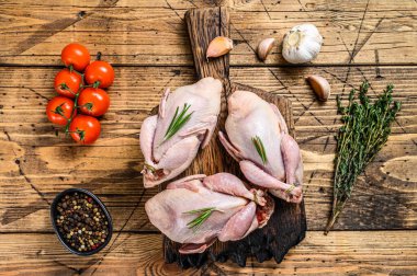 Kesme tahtasında çiğ bıldırcın. Ahşap arka plan. Üst görünüm