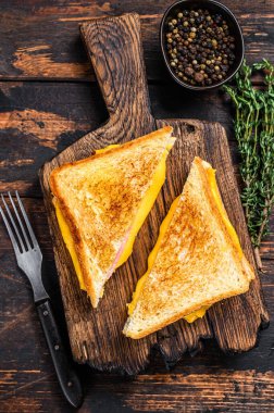 Kızarmış jambon ve erimiş peynirli sandviç. Koyu ahşap arka plan. Üst görünüm