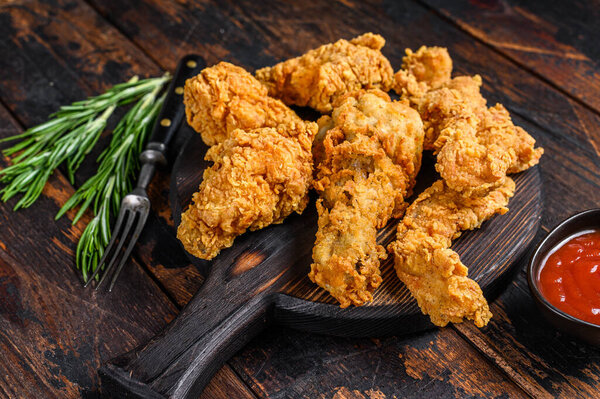 Куриные ножки с хлебом, ножки, крылья и грудные нежные полоски. Темный вуден фон. Вид сверху