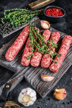 Kesme tahtasında taze çiğ et kebabı sosis. Siyah arka plan. Üst görünüm