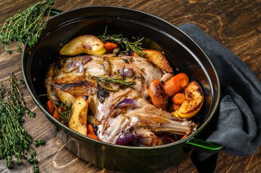 Fırında keçi budu pişirdim. Ahşap arka plan. Üst görünüm