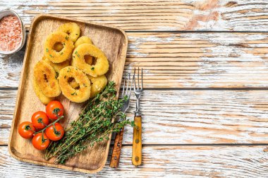 Kızarmış kızarmış soğan halkaları. Beyaz ahşap arka plan. Üst Manzara. Boşluğu kopyala