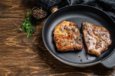 Tavada kızarmış domuz filetosu. Koyu ahşap arka plan. Üst Manzara. Boşluğu kopyala