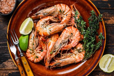 Tabakta ızgara kaplan karidesi. Koyu ahşap arka plan. Üst görünüm