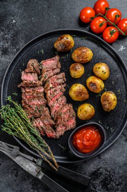 Kızarmış patatesli ızgara biftek. Siyah arka plan. Üst görünüm