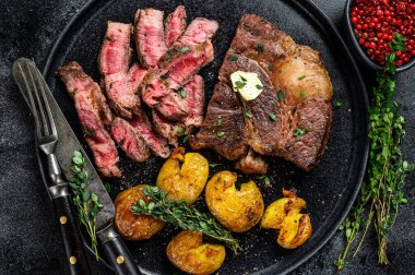 Izgara kaburga bifteği ve patates. Siyah arka plan. Üst görünüm