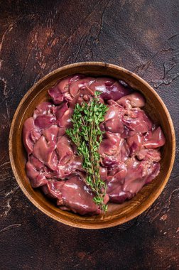 Tahta tabakta çiğ ördek ciğeri. Karanlık arka plan. Üst görünüm