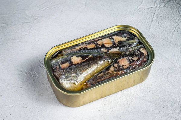 Open can with sardine in olive oil. White background. Top view