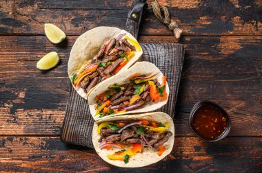 Domuz eti, soğan, domates, tatlı biber ve salsa soslu taco kabuğu. Meksika yemeği. Koyu ahşap arka plan. Üst görünüm.