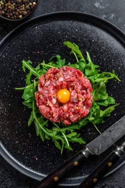 Roka ve bıldırcın yumurtalı sığır eti. Siyah arka plan. Üst görünüm.