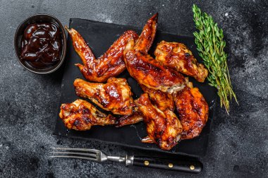 Sucuk soslu ızgara tavuk kanadı. Siyah arka plan. Üst görünüm.