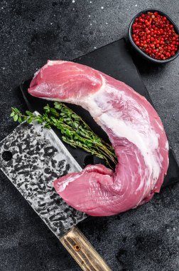 Misket tahtasında çiğ domuz filetosu eti. Siyah arka plan. Üst görünüm.