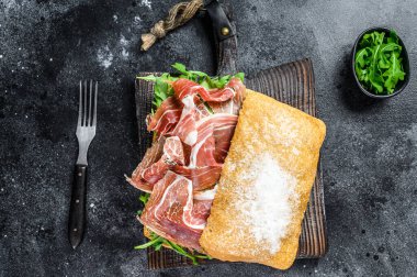 Ciabatta ekmeğinde Iberico Jamon jambonlu sandviç. Siyah arka plan. Üst görünüm.