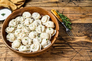 Ev yapımı Rus köfteleri Pelmeni. Tahta bir kasede sığır eti ve domuz eti. Ahşap arka plan. Üst Manzara. Boşluğu kopyala.