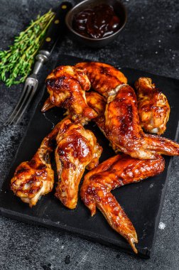 Sucuk soslu ızgara tavuk kanadı. Siyah arka plan. Üst görünüm.