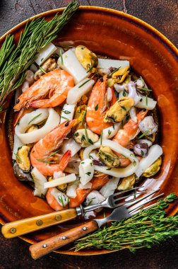 Çiğ deniz ürünleri kokteyli karides, karides, midye, mürekkep balığı ve ahtapotla karıştırılmış. Koyu ahşap arka plan. Üst görünüm.