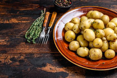 Yeni haşlanmış patates, tereyağı ve doğranmış dereotlu. Karanlık ahşap arka plan. Üst Manzara. Boşluğu kopyala