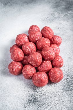 Mutfak masasında baharatlı çiğ biftek ve domuz köftesi. Beyaz arka plan. Üst görünüm