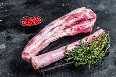 Taze çiğ sığır eti, öküz kuyruğu eti mermer tahtada otlarla birlikte. Siyah arka plan. Üst görünüm