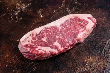 Çiğ New York bifteği ya da kasap masasında striploin. Karanlık arka plan. Üst görünüm
