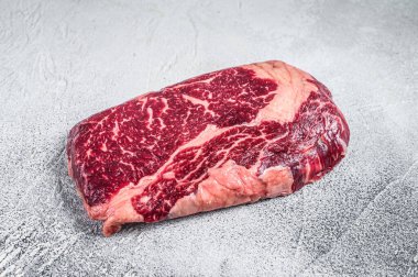 Izgara için hazırlanmış bir masada çiğ biftek bifteği. Beyaz arka plan. Üst görünüm