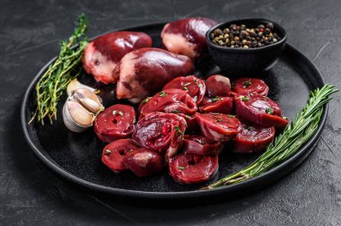 Dilimlenmiş çiğ hindi kalbi pişirmeye hazır. Siyah arka plan. Üst görünüm