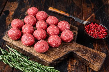 Biberiyeli kıyma ve domuz etinden pişmemiş çiğ köfte. Karanlık ahşap arka plan. Üst görünüm