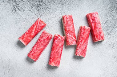 Yengeç surimi mutfak masasına yapışıyor. Beyaz arka plan. Üst görünüm