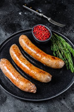 Tabakta baharat ve otlarla kızartılmış sosisler. Üst Manzara. Siyah arkaplan