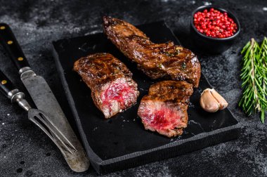 Misket tahtasında barbekü soslu ızgara biftek. Siyah arka plan. Üst görünüm