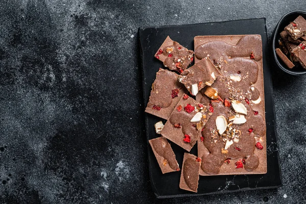 Mermer tahtada el yapımı çikolatalar. Siyah arka plan. Üst Manzara. Boşluğu kopyala