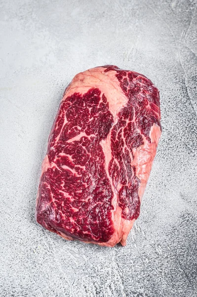 Izgara için hazırlanmış bir masada çiğ biftek bifteği. Beyaz arka plan. Üst görünüm