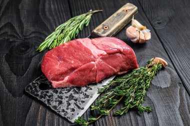 Satırda çiğ kuzu fileto biftek. Siyah ahşap arka plan. Üst görünüm