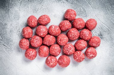 Mutfak masasında baharatlı çiğ biftek ve domuz köftesi. Beyaz arka plan. Üst görünüm