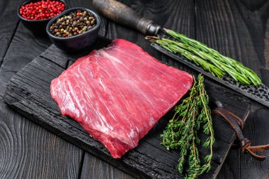 Tahta kesme tahtasının üzerinde çiğ kanat ya da bonfile biftek. Siyah arka plan. Üst görünüm