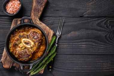 Dana budu, OssoBuco eti, İtalyan osso buco bifteği. Siyah ahşap arka plan. Üst Manzara. Boşluğu kopyala