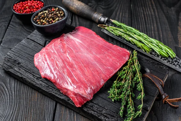 Tahta kesme tahtasının üzerinde çiğ kanat ya da bonfile biftek. Siyah arka plan. Üst görünüm