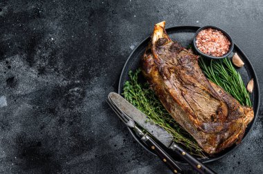 Bıçak ve çatalla tabakta kızarmış koyun eti. Siyah arka plan. Üst Manzara. Boşluğu kopyala