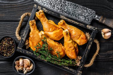 Tütsülenmiş tavuk budu bagetleri ve baharatlar. Siyah ahşap arka plan. Üst görünüm