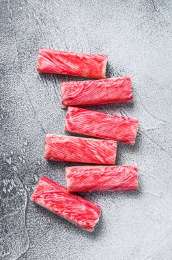 Yengeç surimi mutfak masasına yapışıyor. Beyaz arka plan. Üst görünüm