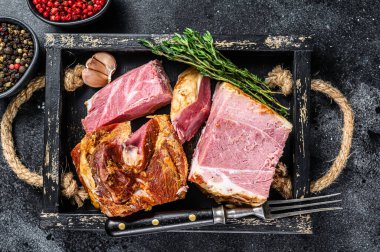 Dilimlenmiş domuz pastırması, ahşap tepside. Siyah arka plan. Üst görünüm