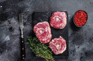 Misket tahtasında çiğ kuzu boynu eti, siyah arka plan. Üst görünüm