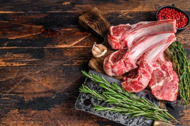 Kasap kesim tahtasında kuzu pirzola bifteği. Koyu ahşap arka plan. Üst Manzara. Boşluğu kopyala