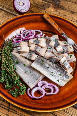 Salamura edilmiş balık salamura edilmiş fileto kekik ve soğanlı bir tabakta. Ahşap arka plan. Üst görünüm
