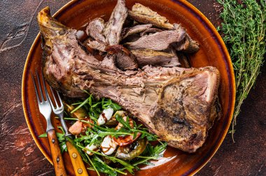 Kızarmış keçi ya da koyun eti, omuz eti ve salata. Karanlık arka plan. Üst görünüm