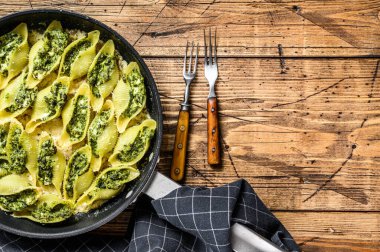 Conchiglioni soslu ıspanak ve peynirle doldurulmuş Jumbo kabuklu makarna. Ahşap arka plan. Üst Manzara. Boşluğu kopyala