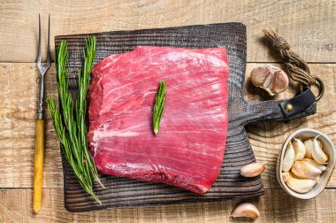 Taze çiğ kanat ya da bonfile biftekli ve biberiyeli biftek. Ahşap arka plan. Üst görünüm
